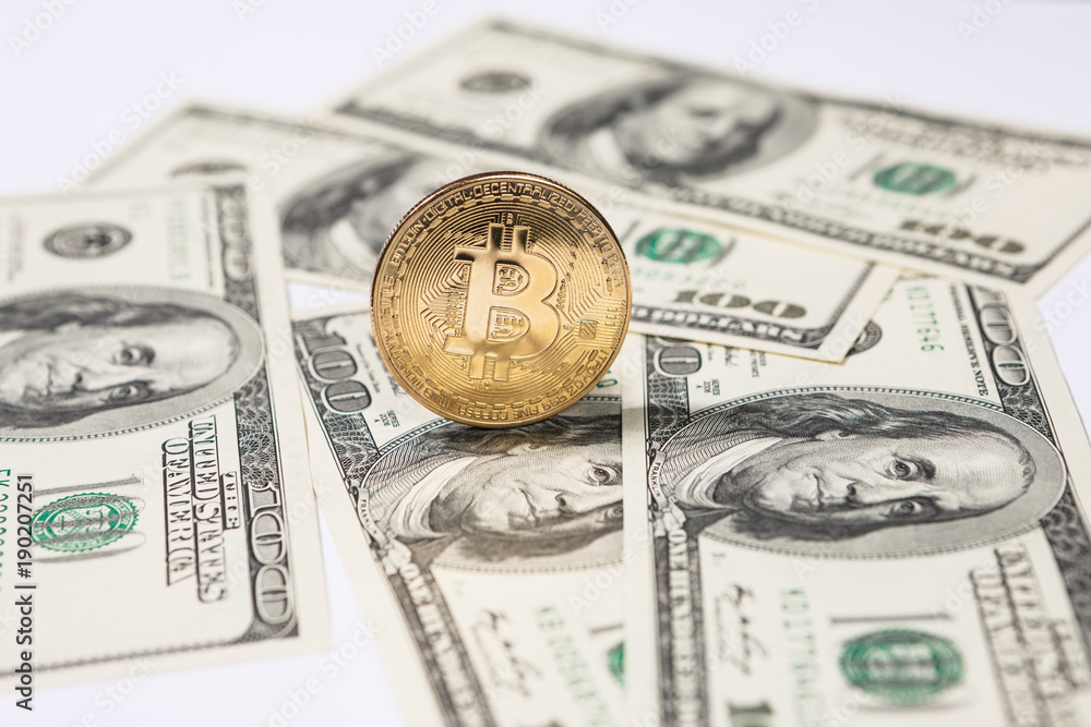 Golden bitcoin coin on us dollars close up. Golden bitcoin coin on us dollars close up.