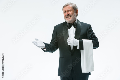 Senior waiter holding white towel