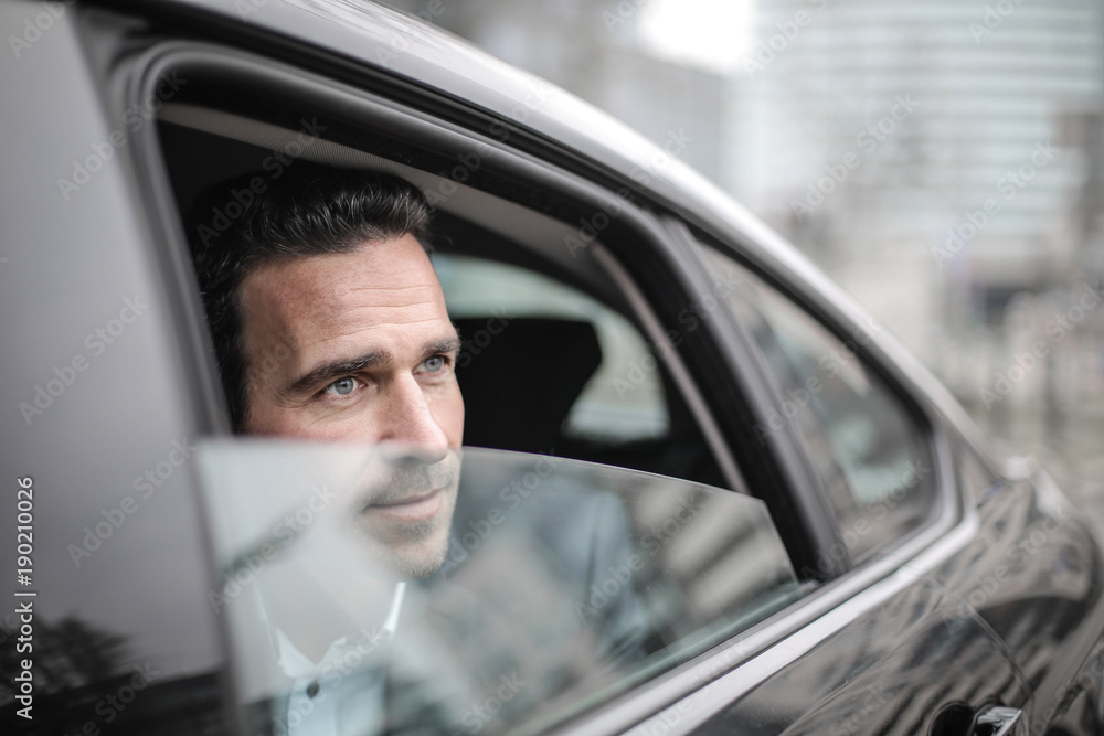 Handsome man looking out from the car’s window Handsome man looking out from the car’s window