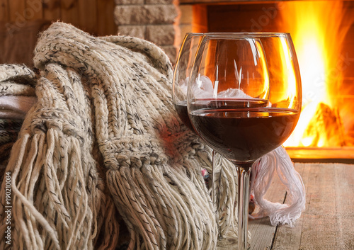 Glass of red wine; and wool; things near cozy fireplace.