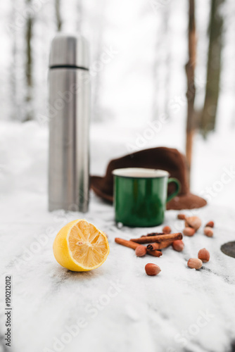 tea with lemon and cardamom on the background of a snow-covered table
