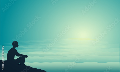 man sits on the sea rock look at the sun and think, think about sense of life, man silhouette