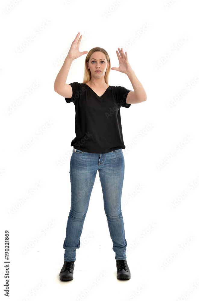 full length portrait of blonde girl wearing black shirt and jeans, standing pose isolated on a white background.