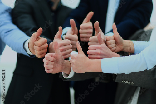 Bilde på lerret Close-up of business team holding their thumbs up.