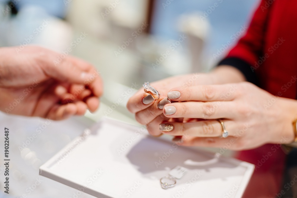 Female seller in a luxury jewelry store presents a ring.