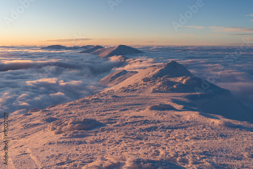 Beautiful sunset above clouds in snow covered Low Tatras mountains during susnet in winter