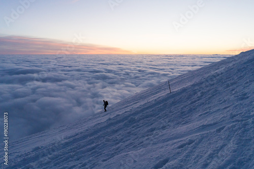 Skiing on snow in Slovak mountains above clouds during sunset in winter