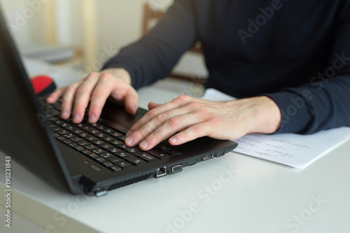 hands of a working man behind a laptop