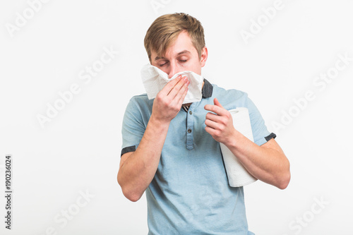 Fotografia Young man has a runny nose on white background