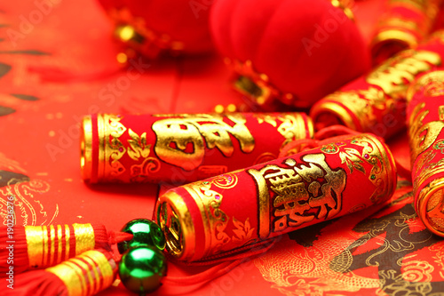 Chinese new year lanterns and fake firecrackers on red background that says good luck and happiness