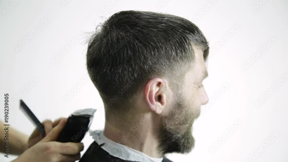Haircut at barbershop. hairdresser uses scissors for cutting a man Haircut at barbershop. hairdresser uses scissors for cutting a man