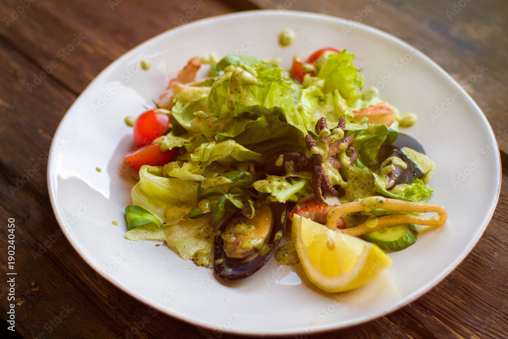 Tasty salad with seafood on a white plate Tasty salad with seafood on a white plate