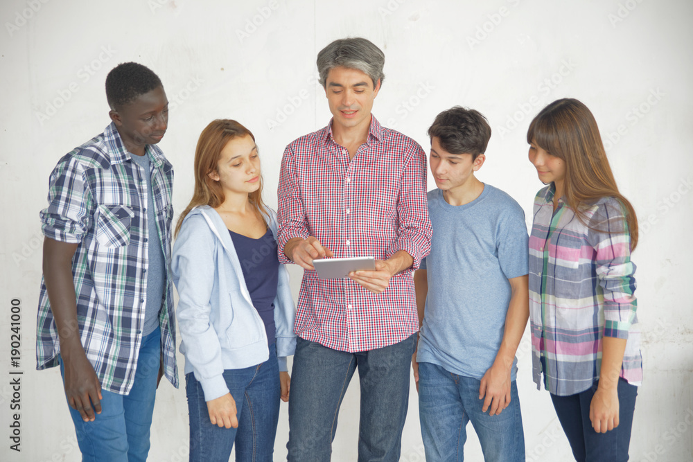Obraz premium Teenagers classmates with teacher explaining with tablet