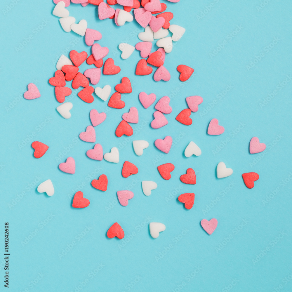 Candies hearts of pastel colors on blue paper. Flat lay. Candies hearts of pastel colors on blue paper. Flat lay.