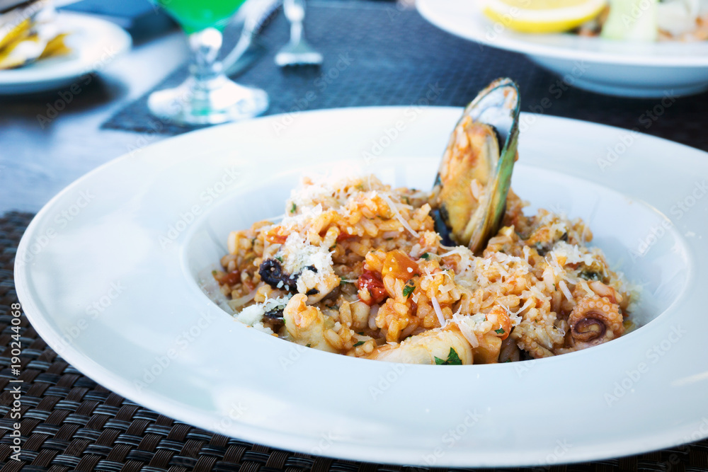 Tasty risotto with Shrimp, fresh herbs vegetables on a white plate Tasty risotto with Shrimp, fresh herbs vegetables on a white plate