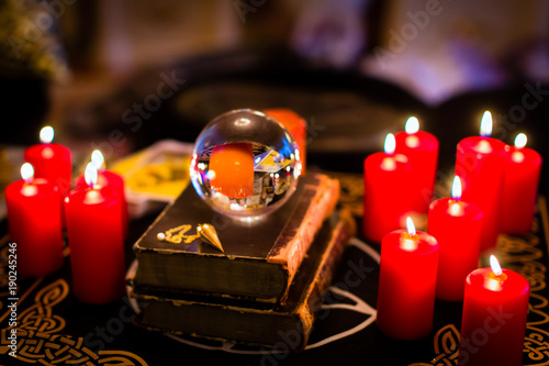 Crystal ball to prophesy or esoteric clairvoyance during a Seance in the candle light photo