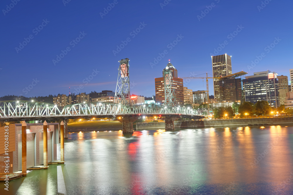 PORTLAND, OREGON - AUGUST 21, 2017: City night skyline along the river. Portland attracts 5 million people annually