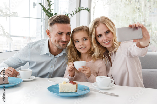 beautiful young family taking selfie at restaurant