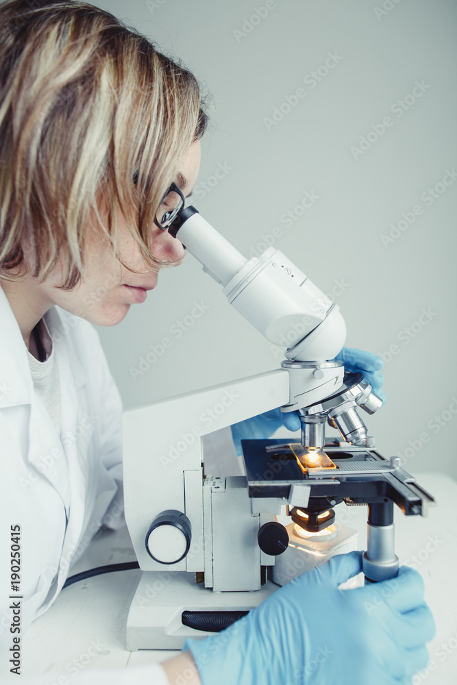 Close up of examining of test sample under the microscope in laboratory. Close up of examining of test sample under the microscope in laboratory.