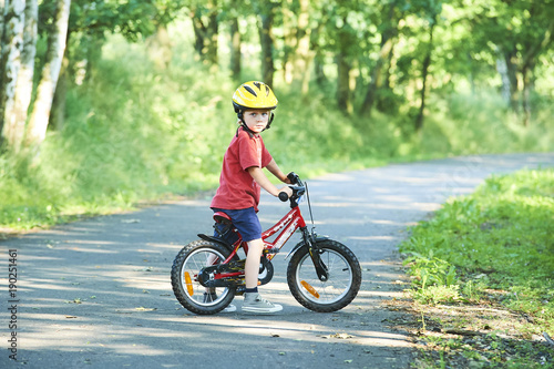 Portrait of a cute boy on bicycle  wearing safety helmet