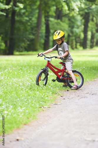 Portrait of a cute boy on bicycle, wearing safety helmet