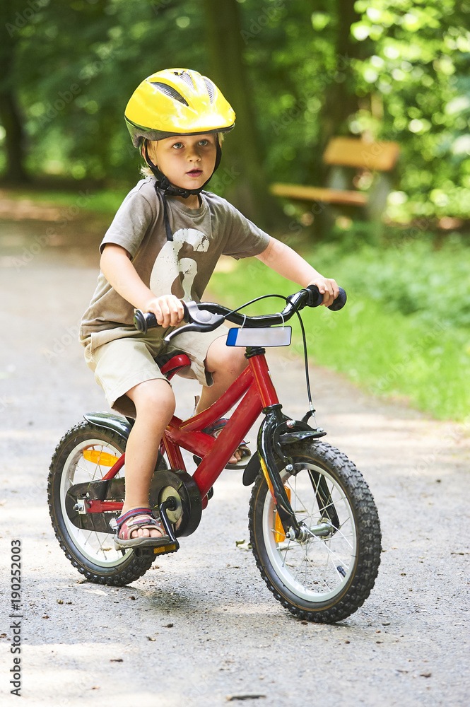 Portrait of a cute boy on bicycle, wearing safety helmet Portrait of a cute boy on bicycle, wearing safety helmet
