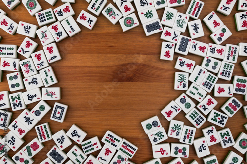 White-green tiles for mahjong on a brown wooden background. Empty place in the center.