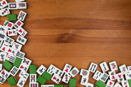 White-green tiles for mahjong on a brown wooden background. Empty place in the upper right corner