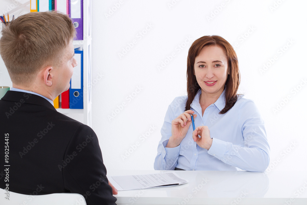 Man is interviewed at office background. Businesswoman and businessman have meeting and conversation. Copy space and mock up. Selective focus Man is interviewed at office background. Businesswoman and businessman have meeting and conversation. Copy space and mock up. Selective focus