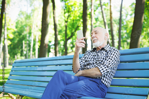 Happy senior man in earphones outdoors