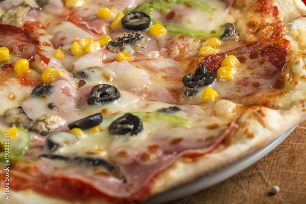 Italian Capriciosa pizza made with salami and vegetables on plate Italian Capriciosa pizza made with salami and vegetables on plate