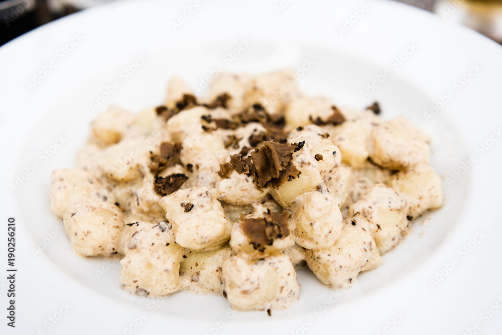 Potato gnocchi, Italian potato dumplings with truffle mushrooms and cheese sauce on a plate close up. Potato gnocchi, Italian potato dumplings with truffle mushrooms and cheese sauce on a plate close up.