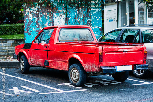 Red retro car in poor technical condition is parked in a taxi parking place. © Slava