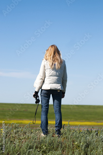 Woman with binoculars in the endless steppe. © Юрий Бартенев