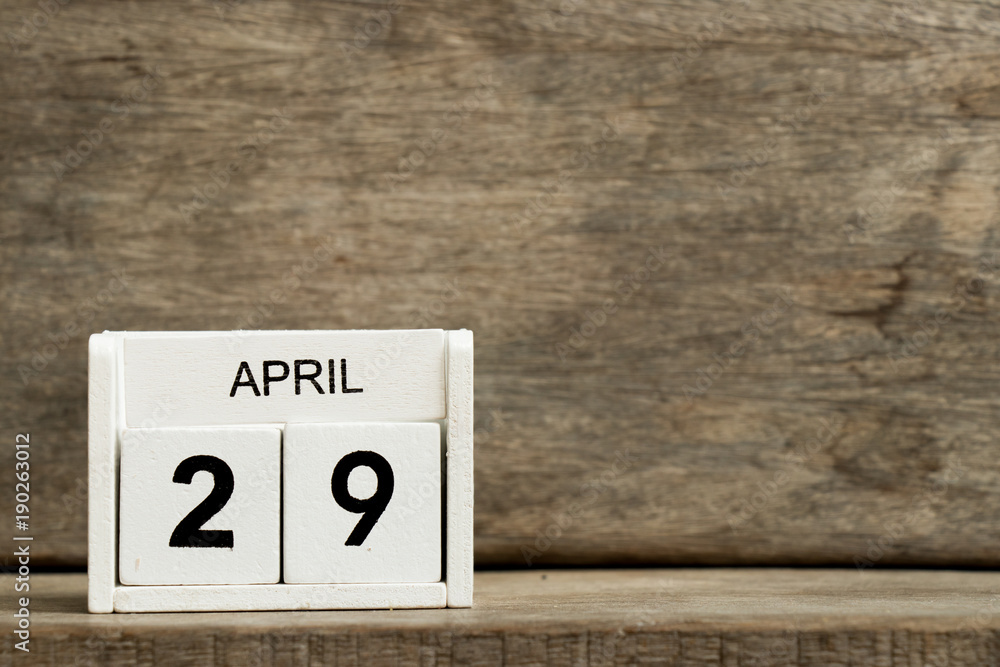 White block calendar present date 29 and month April on wood background White block calendar present date 29 and month April on wood background