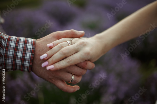 Man holding woman's hands, Lavender field. Valentine's day concept 