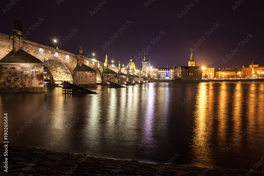 Charles Bridge and buildings along the Vltava at night, in Prague, Czech Republic