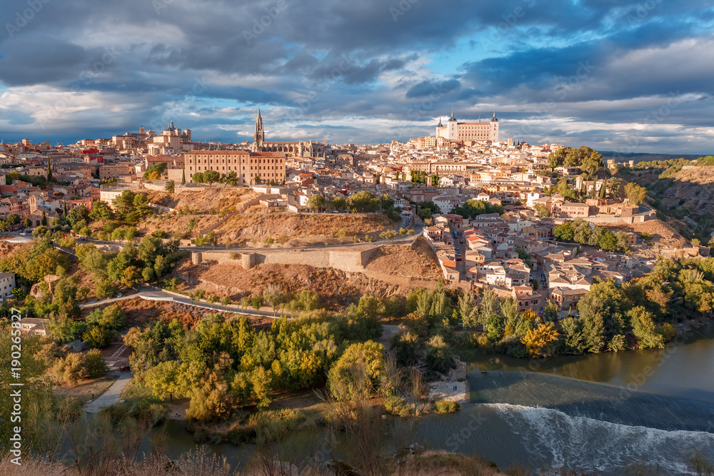 Panoramic aerial view of Old city of Toledo with Cathedral, Alcazar and river Tajo at dusk, Castilla La Mancha, Spain