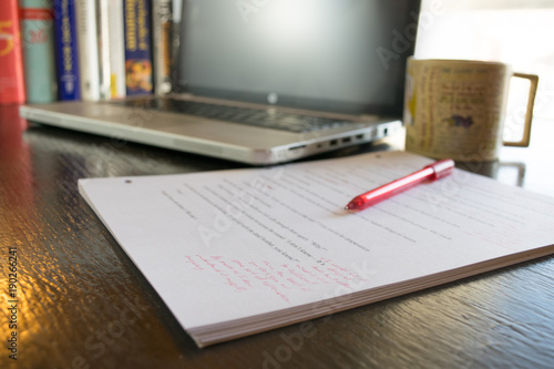 Office Desk with marked up paper computer coffee and pen