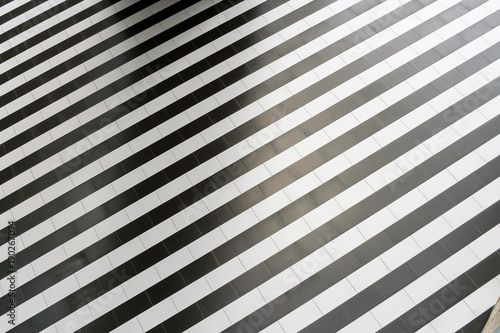 Abstract geometric pattern of regular alternating black and white stripes on the floor.