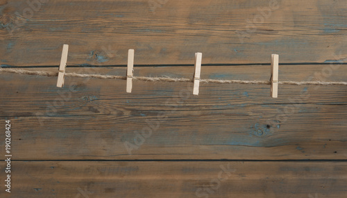 wooden clothespins on rope against old wood plank wall