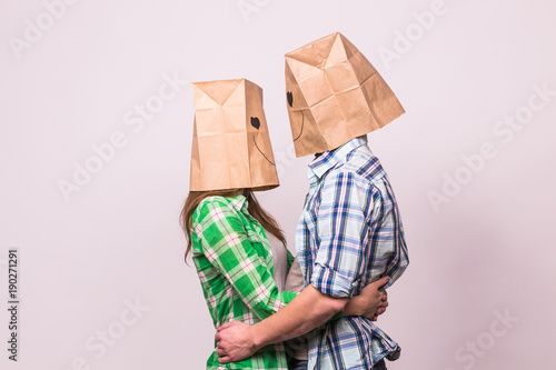 Valentine's day concept - Young love couple with bags over heads on white background