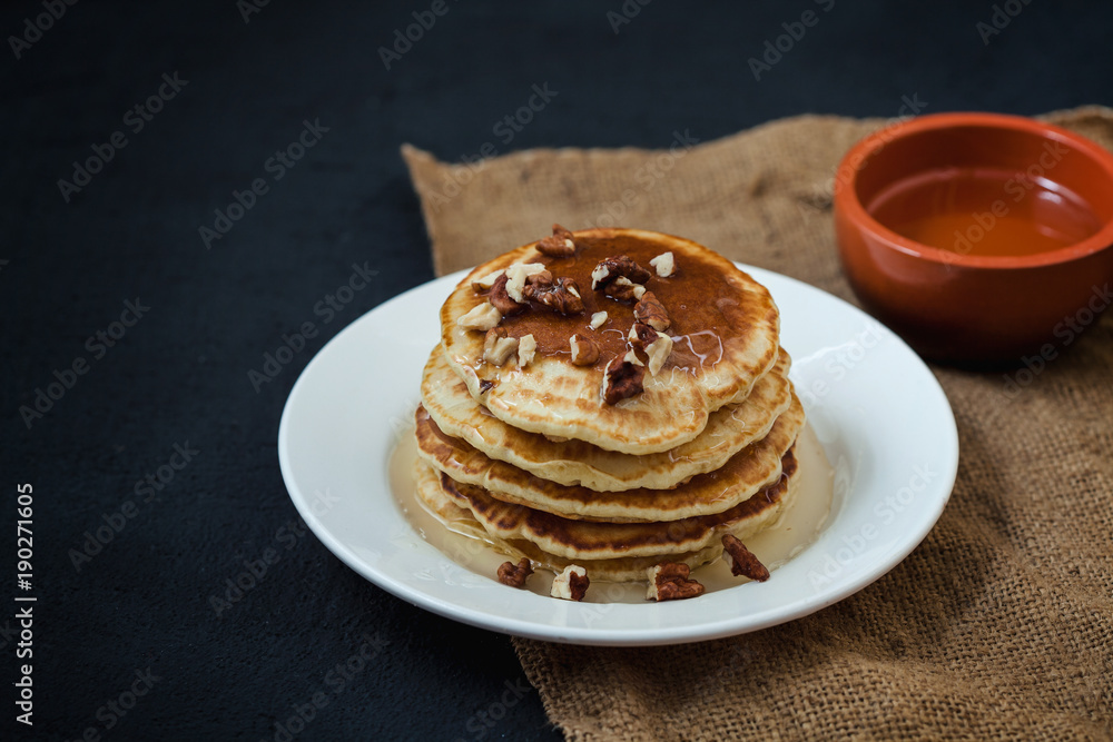 appetizing Pancakes with honey and nuts on a dark table. Menu , restaurant recipe concept. Served in appetizing Pancakes with honey and nuts on a dark table. Menu , restaurant recipe concept. Served in
