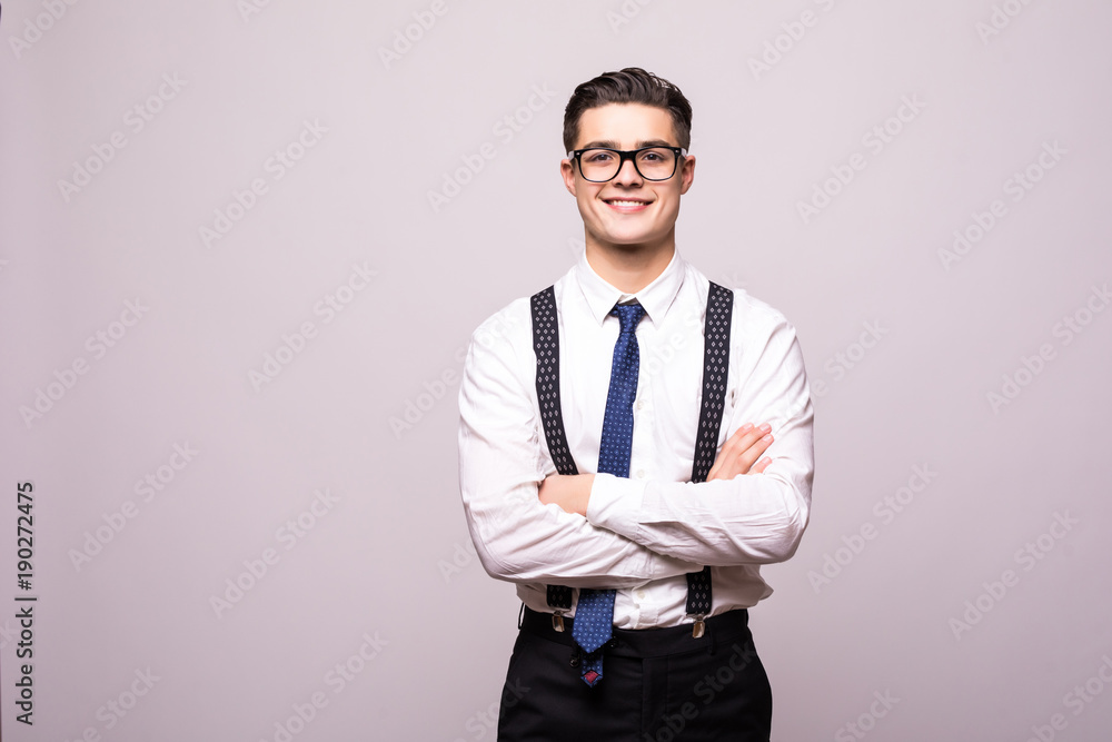 Portrait of happy smiling young man wearing a white shirt standing with hands folded against isolated on white background Portrait of happy smiling young man wearing a white shirt standing with hands folded against isolated on white background