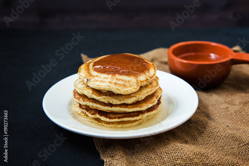 appetizing pancakes with honey on a dark table. Menu , restaurant recipe concept. Served in.