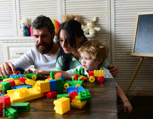 Young family spends time in playroom. Parents and son