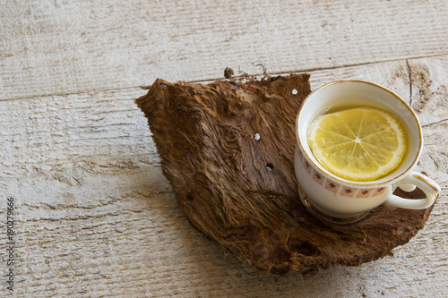 Cup of tea on wooden table with space fot text photo