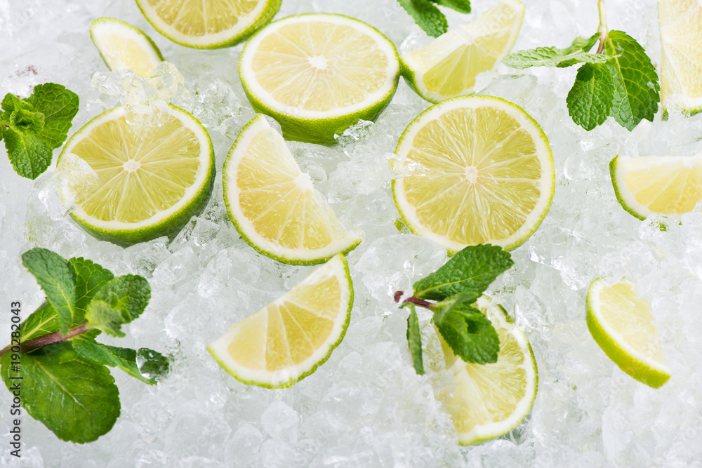 Juicy lime fruits on ice cubes background. Juicy lime fruits on ice cubes background.
