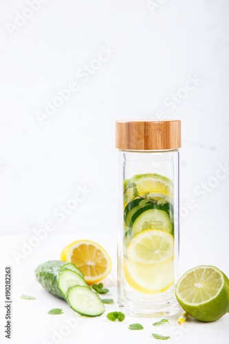 Detox Infused Water with Lemon, Lime,Cucumber and Mint in Sports Glass Bottle on a White Background.Healthy Beverage.Food diet concept.Vegetarian.Copy space for Text. selective focus.