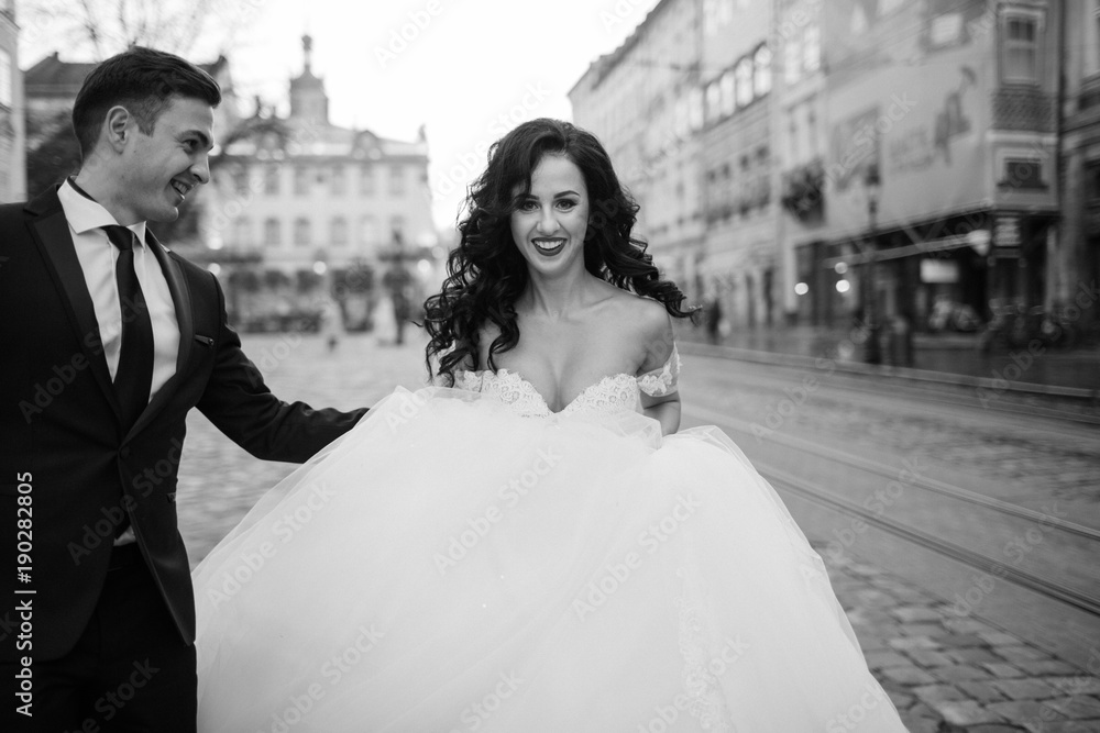 Bride and groom walking through the old town Bride and groom walking through the old town